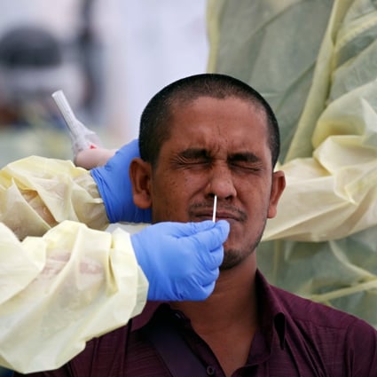 Medical workers perform a nose swab on a migrant worker at a dormitory in Singapore in May. Photo: Reuters