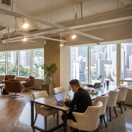People wearing masks sit with their laptops at The Executive Centre’s co-working space in Hong Kong. Photo: Bloomberg