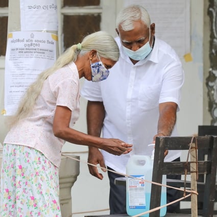 A voter uses hand sanitiser before entering a polling station during the parliamentary elections in Sri Lanka last week. Photo: EPA