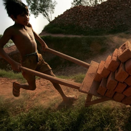 A child worker pushes a cart with bricks in Meerut city, India. File photo: EPA