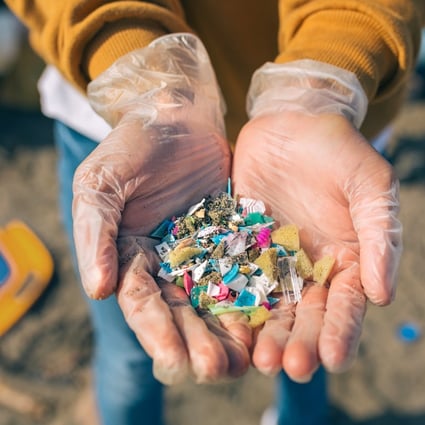 Detail of hands showing microplastics on the beach. Photo: Shutterstock