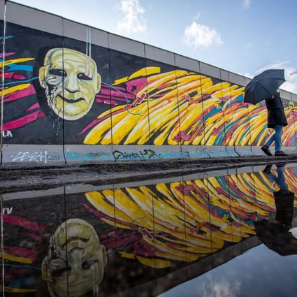A visitor is reflected in a puddle along the East Side Gallery in Berlin. The lack of a geopolitical focal point akin to Berlin during the Cold War is one of several reasons that drawing parallels between US-China and US-Soviet-Union competition misses the mark. Photo: EPA