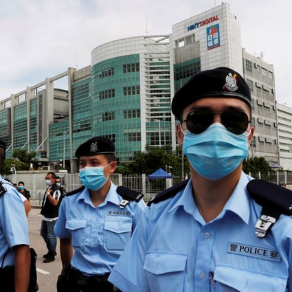 Police officers stand guard outside the headquarters of Apple Daily and Next Media. Photo: Reuters