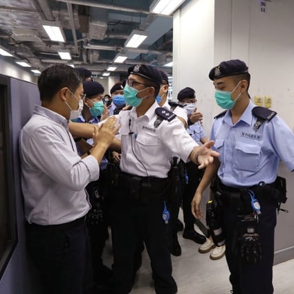 Apple Daily's editor-in-chief, Ryan Law (left), tries to stop police searching the newspaper’s editorial department. Photo: Handout