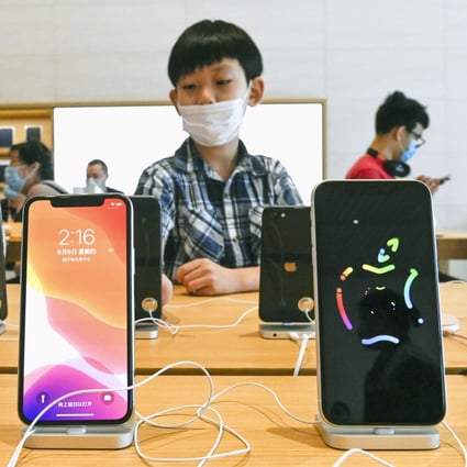Shoppers check out the latest iPhone models at an Apple Store in Beijing on August 6. Photo: Kyodo