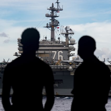 US Navy personnel on board the USS Nimitz aircraft carrier with the USS Ronald Reagan in the background. Photo: EPA-EFE