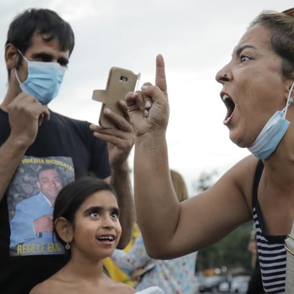 A woman shouts against the government's measures to prevent the spread of Covid-19 infections, like wearing a face mask, during a rally in Bucharest, Romania. Photo: AP