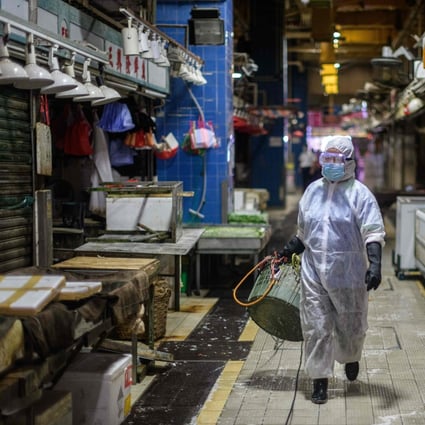 A Food and Environmental Hygiene Department contractor cleans and disinfects Pei Ho Street Market in the Sham Shui Po district of Hong Kong on July 17, amid a third wave of Covid-19. Photo: AFP