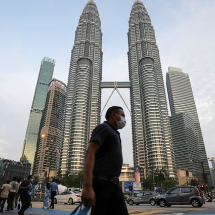 A man walks in front of the Petronas Twin Towers in Kuala Lumpur. Malaysia’s economy contracted in the second quarter as a result of the Covid-19 restrictions. Photo: Reuters