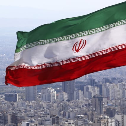 Iran's national flag waves as the Milad telecommunications tower and buildings are seen in Tehran, Iran. Photo: AP