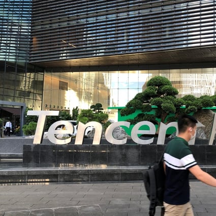 People walk past a Tencent sign at the company headquarters in Shenzhen. Photo: Reuters