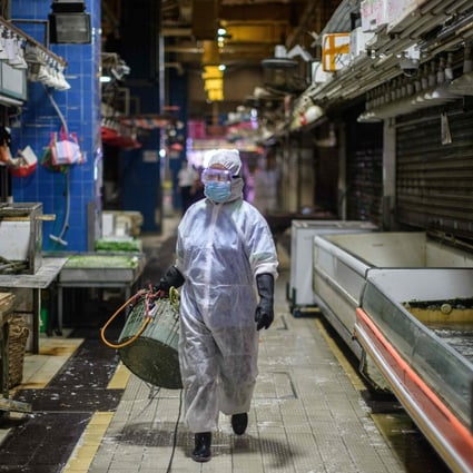 A Food and Environmental Hygiene Department contractor takes part in a cleaning and disinfection of Pei Ho Street Market in Hong Kong’s Sham Shui Po district last month. Photo: Anthony Wallace/AFP