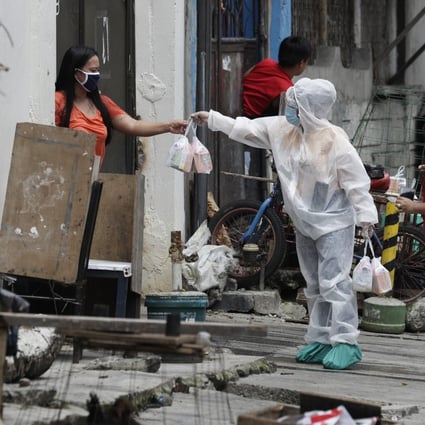 A health worker distributes medicines and vitamins to a resident of an area placed under stricter lockdown measures to curb the spread of Covid-19 in the Philippines. Photo: AP