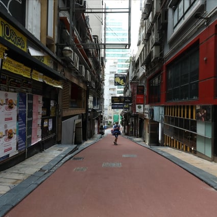 A lone person walks down a street lined by closed bars in Lan Kwai Fong, Central, amid the third wave of coronavirus infections on July 29. Photo: Nora Tam