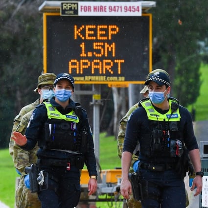 Police officers and soldiers patrol a popular running track in Melbourne. Photo: AFP