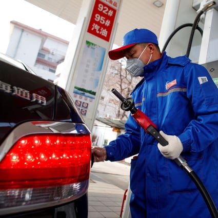 A pump attendant refuels a car at a gas station in Beijing on February 28. Photo: Reuters