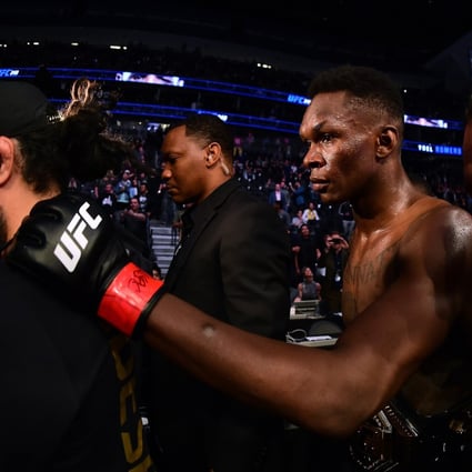 Israel Adesanya is escorted out of the ring after a decision win over Yoel Romero during a middleweight title bout at UFC 248. Photo: AFP
