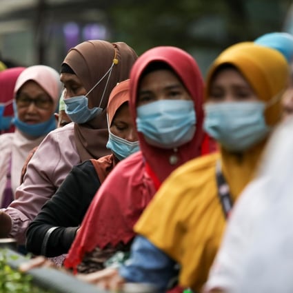 Women queue at a bus station in Kuala Lumpur, Malaysia. Photo: Reuters