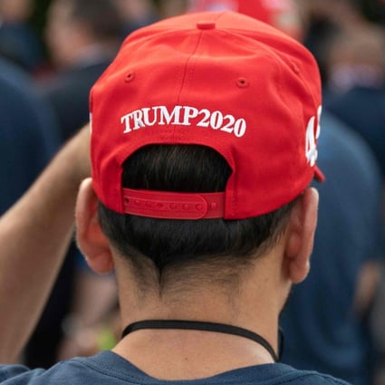 A supporter puts on a MAGA hat as US President Donald Trump speaks in Bedminster, New Jersey, on Friday. Photo: AFP