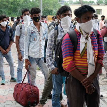 Migrant workers arriving from neighbouring states queue for Covid-19 testing in New Delhi. Photo: Bloomberg