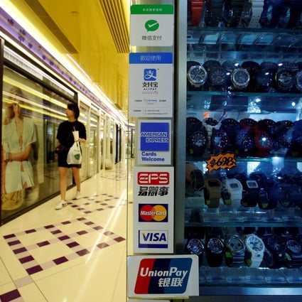 Digital payment brands are displayed outside a watch shop in a mall in Hong Kong. Photo: Reuters