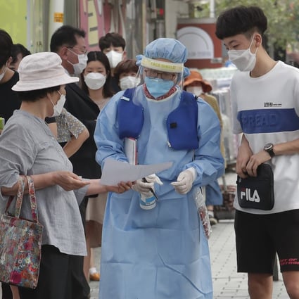 A Seoul medical worker guides patients through a Covid-19 testing facility. Photo: AP