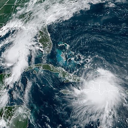 This satellite image shows Tropical Storm Laura moving over Haiti and the Dominican Republic in the Caribbean as a second storm, named Marco (upper left), moves into the Gulf coast on Sunday. Image: RAMMB/NOAA via AFP