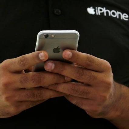 A salesman uses his iPhone at a mobile phone store in New Delhi, India. The country’s 1.3 billion people represents a large, underserved smartphone market that is becoming an increasingly important focus for Apple. Photo: Reuters