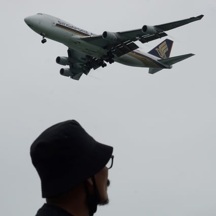 A man looks on as a Singapore Airlines plane approaches for landing at Changi International Airport in Singapore. Photo: AFP
