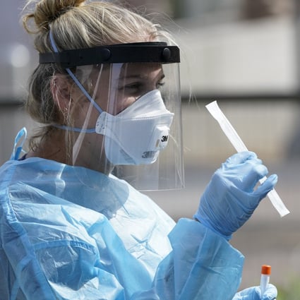 Nurse practitioner Debbi Hinderliter collects a sample from a woman at a coronavirus testing site in San Diego. Photo: AP