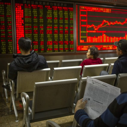 A Chinese investor reads a newspaper as she monitors stock prices at a brokerage house in Beijing. Photo: AP