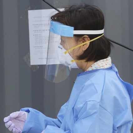 A medical worker measures his own body temperature at a makeshift clinic in Seoul. Photo: AP