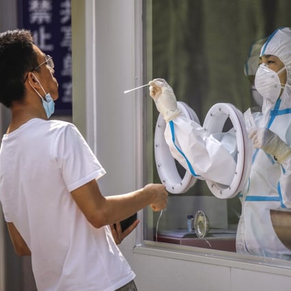 A medical worker wearing a full protective outfit tests a man for the novel coronavirus at a hospital in Beijing, China, 14 July 2020. Photo: EPA-EFE