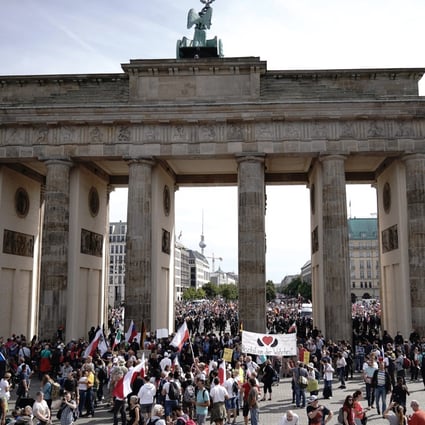 People hold banners and flags during a rally against the coronavirus measures in Berlin. Photo: DPA