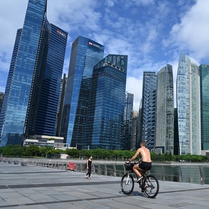 Cyclists pedal down the Marina Bay promenade, flanked by skyscrapers housing banks and other financial institutions, in Singapore. Photo: AFP