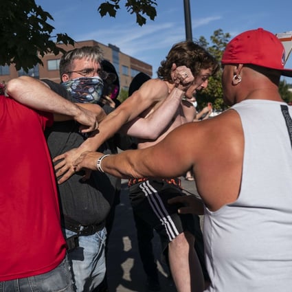 A Black Lives Matter protester scuffles with attendees of a pro-Trump rally during in Oregon on Saturday. Photo: AFP