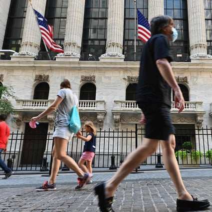 People pass by the New York Stock Exchange on Wall Street in New York City on August 3. Wall Street flexed its muscles on August 28, with the Dow erasing its losses for the year and the S&P and Nasdaq again hitting records as investors shrugged off the ongoing coronavirus crisis. Photo: AFP