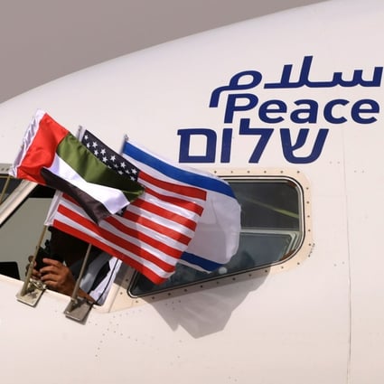 The Emirati, Israeli and US flags are picture attached to an El Al plane adorned with the word “peace” in Arabic, English and Hebrew, upon its arrival at the Abu Dhabi airport after the first-ever commercial flight from Israel to the UAE. Photo: AFP