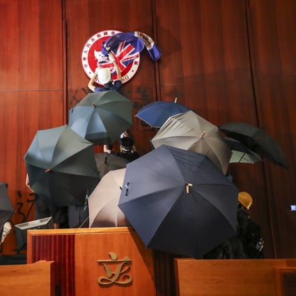 Protesters storm Hong Kong’s Legco chamber last year. Police are now hunting for suspects involved in the case. Photo: Sam Tsang