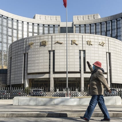 A pedestrian wearing a protective mask walks past the People’s Bank of China building in Beijing on March 17. China suffered an even deeper slump than analysts feared at the start of the year as the coronavirus shuttered factories, shops and restaurants across the nation, underscoring the fallout now facing the global economy. Photo: Bloomberg