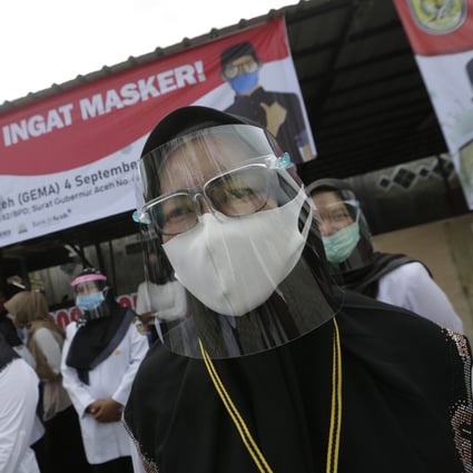 An Indonesia government officer wears a face shield during a protective mask use campaign in Banda Aceh. Photo: EPA