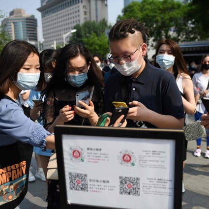 People with face masks have their health codes scanned in Beijing to get into a shopping centre on May 2. Photo: AFP