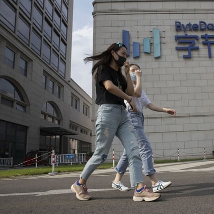 Women wearing masks to prevent the spread of the coronavirus chat as they pass by the ByteDance headquarters in Beijing, China on Friday, Aug. 7, 2020. Photo: AP