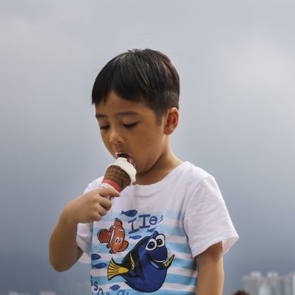 A boy eats ice cream near Victoria Harbour in Hong Kong on July 31, 2017, when the Observatory issued a “very hot” weather warning. This year, Hong Kong experienced its hottest July since records began. Photo: Felix Wong