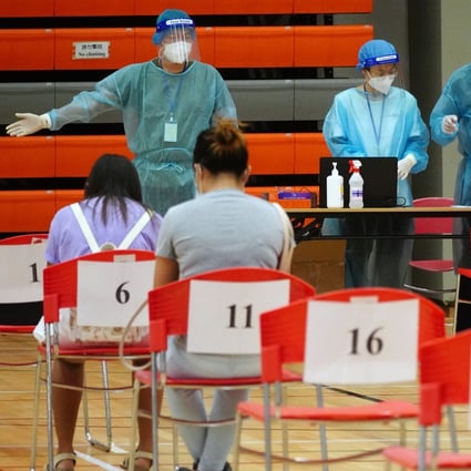 Domestic helpers wait to be tested at the Harbour Road Sports Centre in Wan Chai. Photo: Sam Tsang