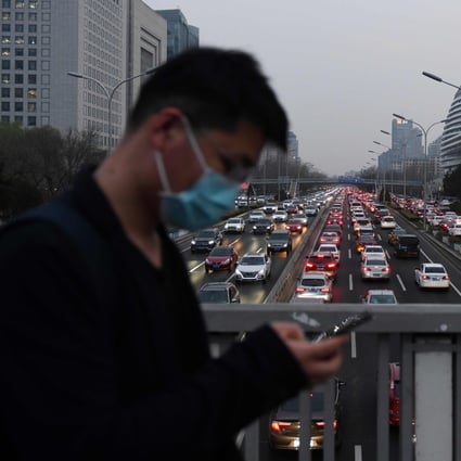 A man walks past Beijing’s Second Ring Road crowded with cars on March 24. Photo: AFP