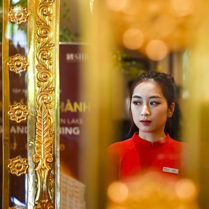 A staff member waits to welcome guests in the lobby of the newly inaugurated Dolce Hanoi Golden Lake hotel, the world's first gold-plated hotel, in Hanoi on July 2. From an investor perspective, gold has been a safe haven for thousands of years. Photo: AFP