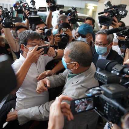 Apple Daily founder Jimmy Lai navigates a crowd of journalists outside West Kowloon Court on Thursday after being found not guilty of intimidating a reporter from a rival newspaper. Photo: Winson Wong