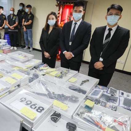 Hong Kong police pose with evidence taken during a three-day operation that saw 15 suspected members of a triad gang arrested. Photo: Nora Tam