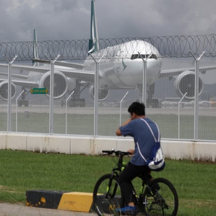 Two cyclists pass a line of grounded Cathay Pacific aircraft at Hong Kong International Airport. Photo: Sam Tsang
